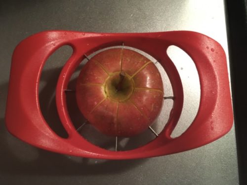 リンゴカッターでリンゴを半分押しつぶした図