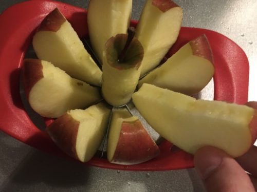 リンゴカッターで切り分けたリンゴを手に取った図